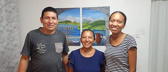 [Translate to English:] eine Afro-Ecuadorianerin, eine ältere Dame aus dem Hochland und ein Familienvater hellerer Hautfarbe arbeiten nach ihrer Versöhnung gut zusammen